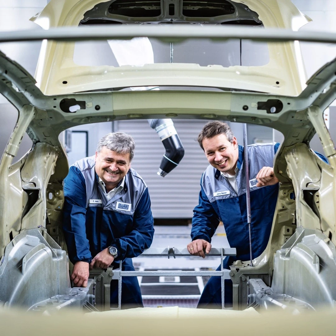 employees looking into a car body