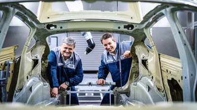 employees looking into a car body