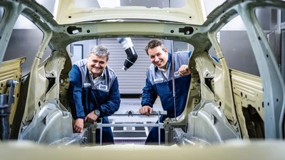 employees looking into a car body