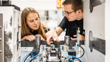 Apprentices working on a machine