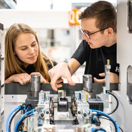 Apprentices working on a machine