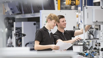 apprentices working on a machine