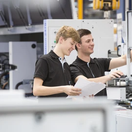 apprentices working on a machine