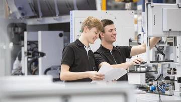 apprentices working on a machine