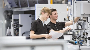 apprentices working on a machine