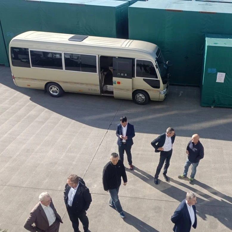 The members of the management in front of a sand-colored minibus