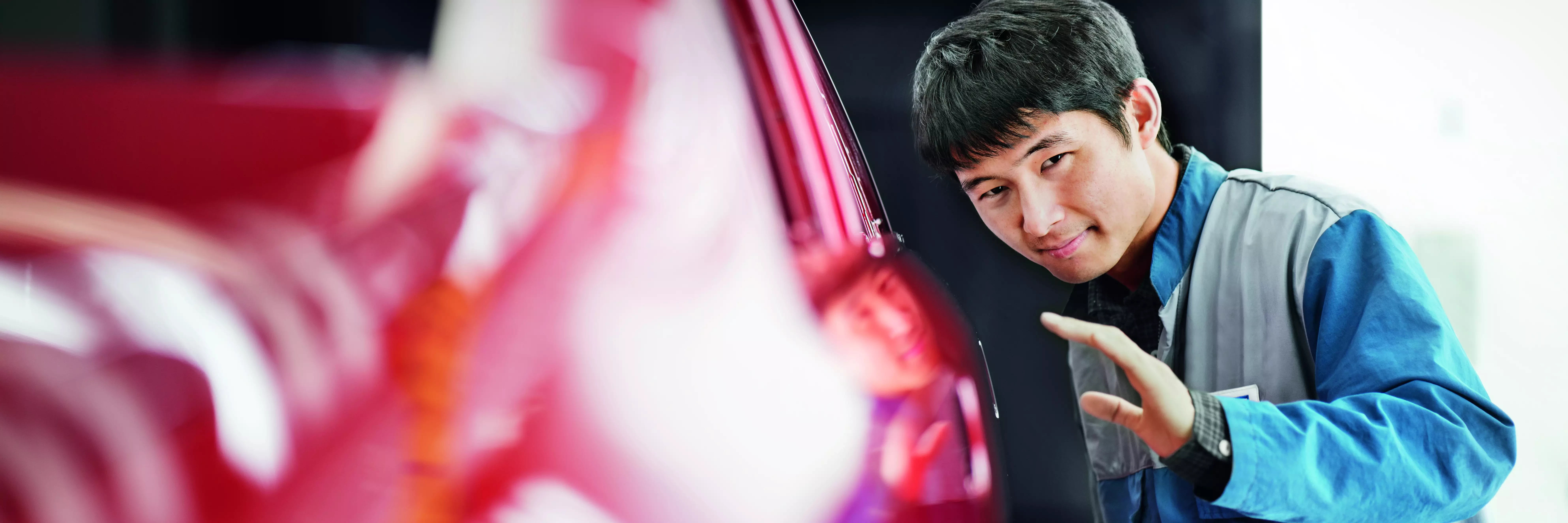 Perfect finish Employee checking the paint finish of a car