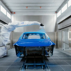 Lackierroboter lackiert blaues Auto