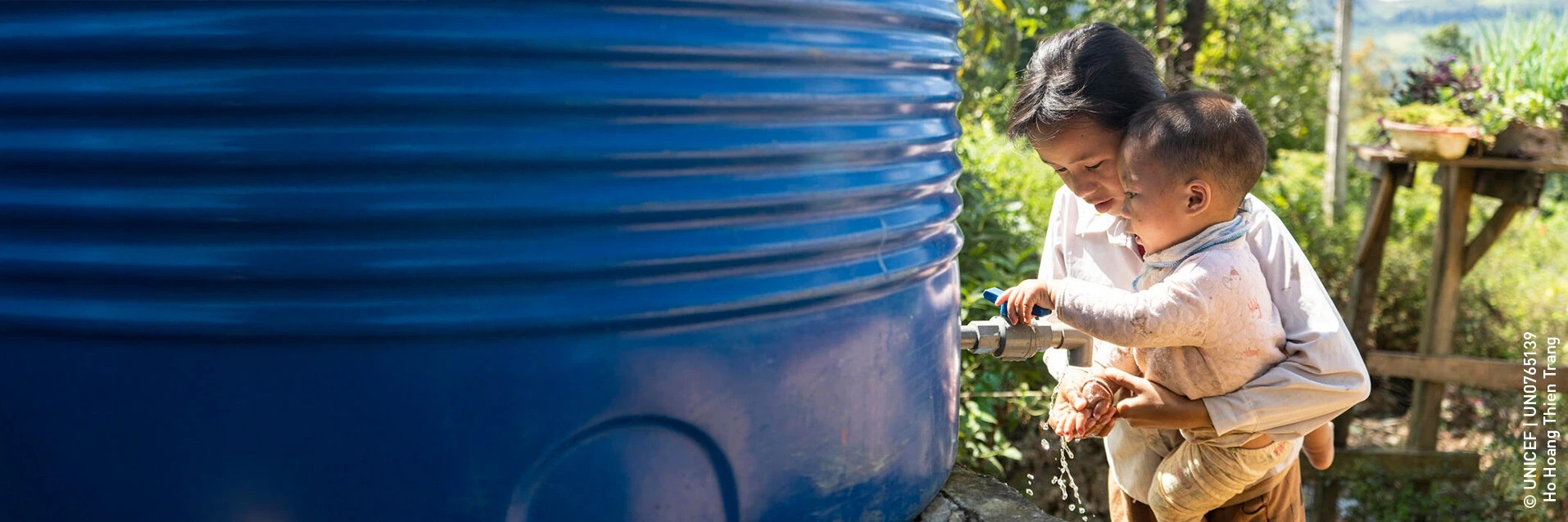 A woman with a child washing their hands
