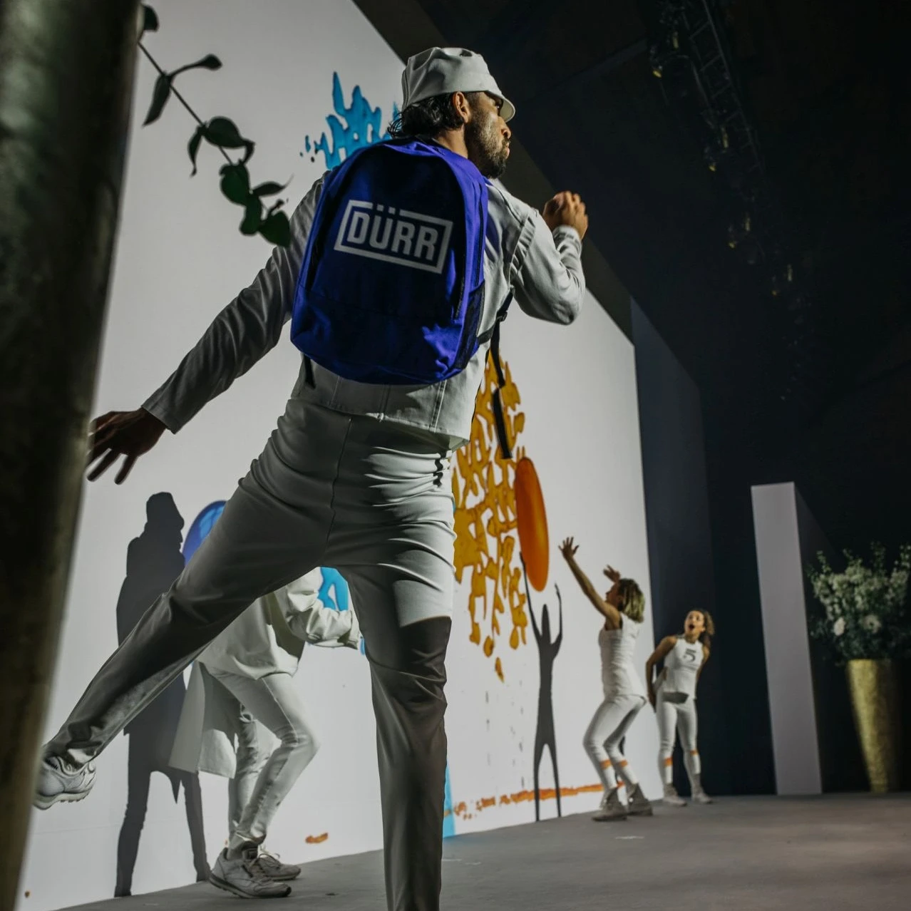 Tänzer mit Dürr-Rucksack auf der Bühne