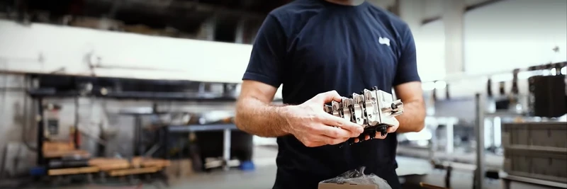 Dürr employee holding a component in his hand