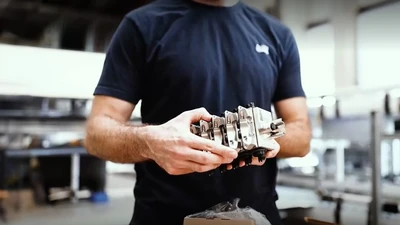 Dürr employee holding a component in his hand