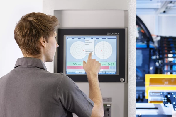 employee monitoring the condition of a balancing machine 