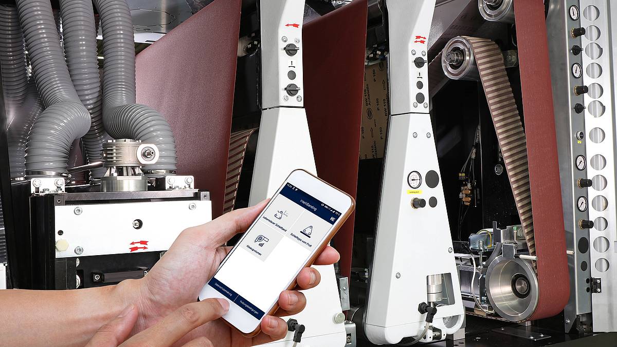 intelliSanding App auf Handy vor Maschine
