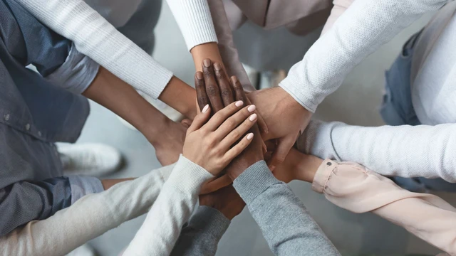 Business team putting hands together on top of each other