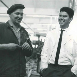 Heinz Dürr laughing while talking to two employees