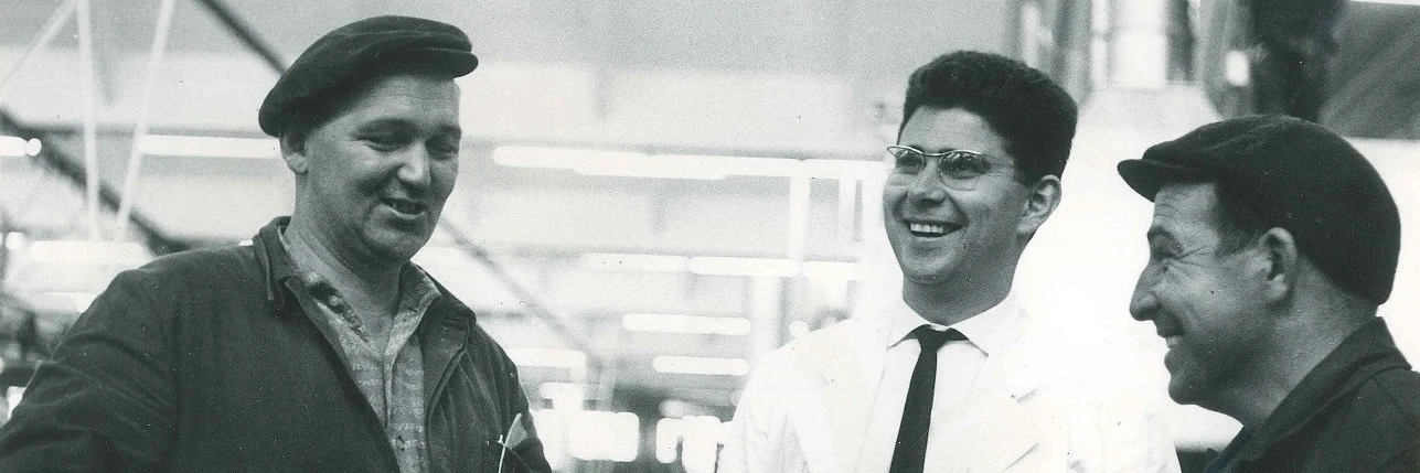 Heinz Dürr laughing while talking to two employees